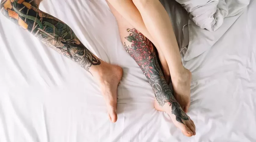 on bed two legs have tattoo and two didn't