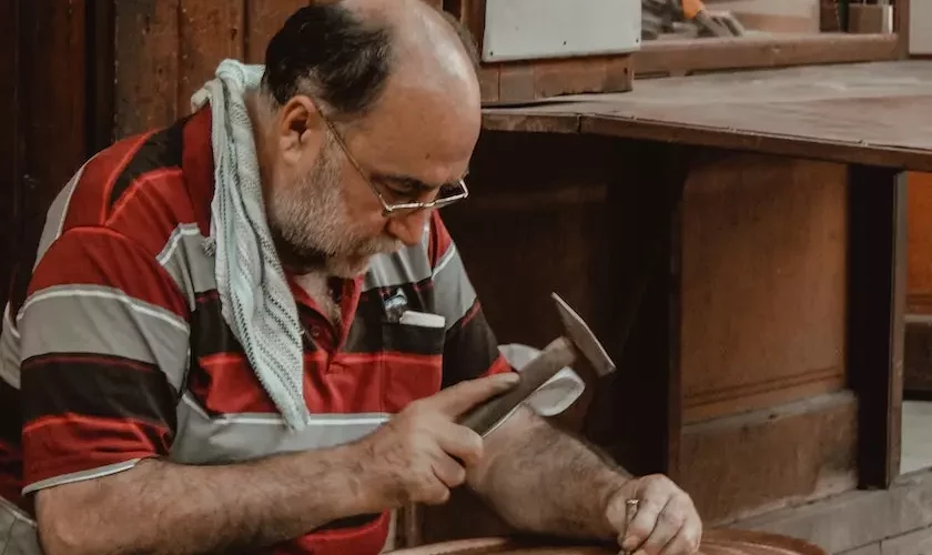 a bald man is hammering the nail
