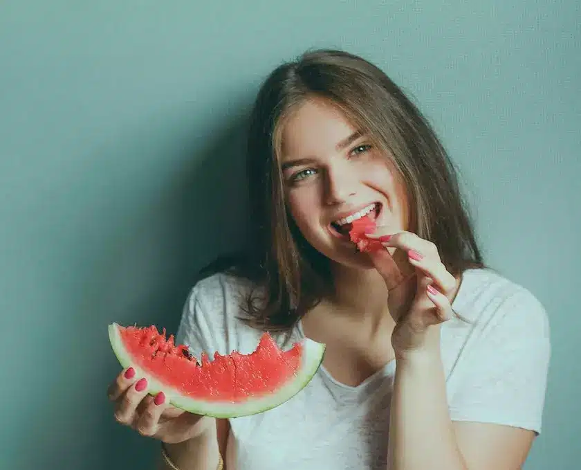 A girl is eating a watermelon