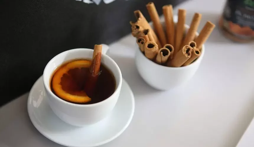 A white cup of cinnamon sticks and tea