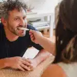 a man is eating something from a woman's hand