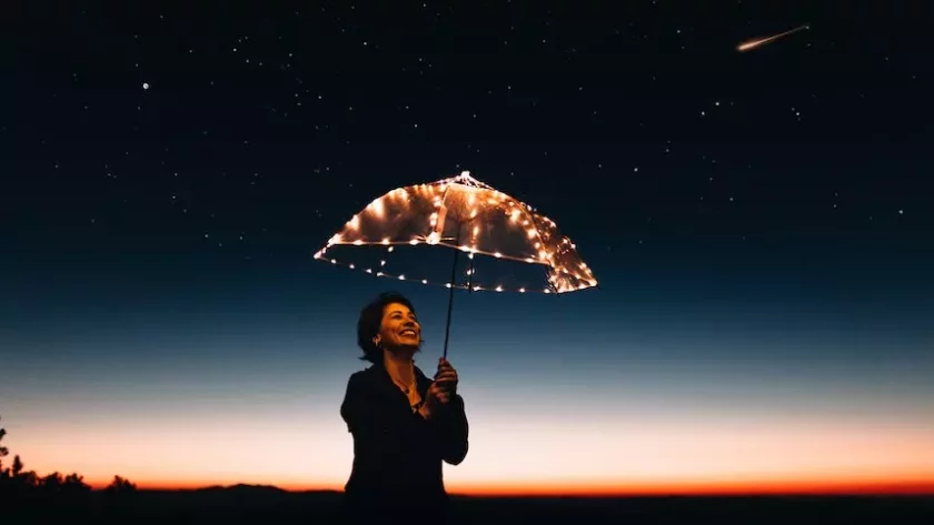 a smiling woman holding an umbrella