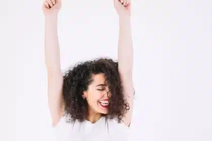 a woman is laughing with her hands up