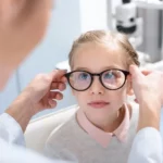 A doctor test glasses on a girl