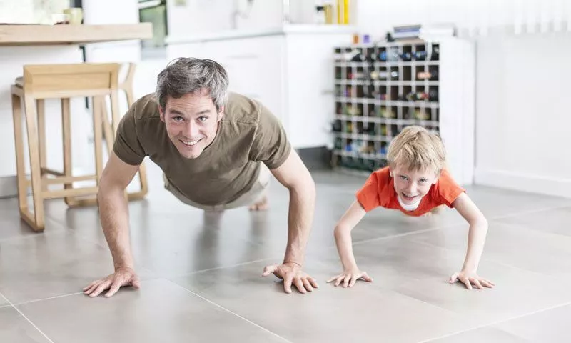 A child and a man doing pushups