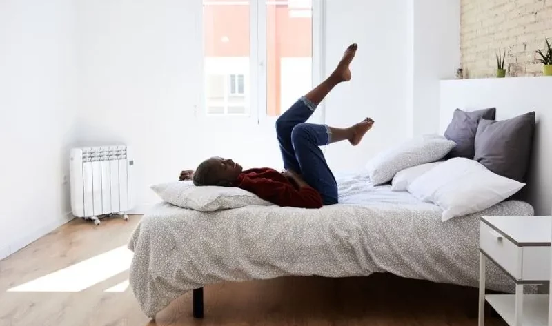 A girl is lying on the bed with her feet up