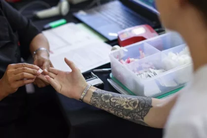 A tattooed person is donating blood