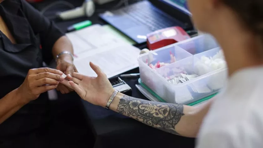 A tattooed person is donating blood