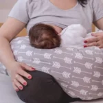 A woman breastfeeding a baby during a blocked milk duct condition