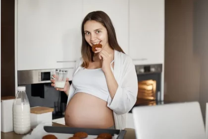 A pregnant lady eating a food