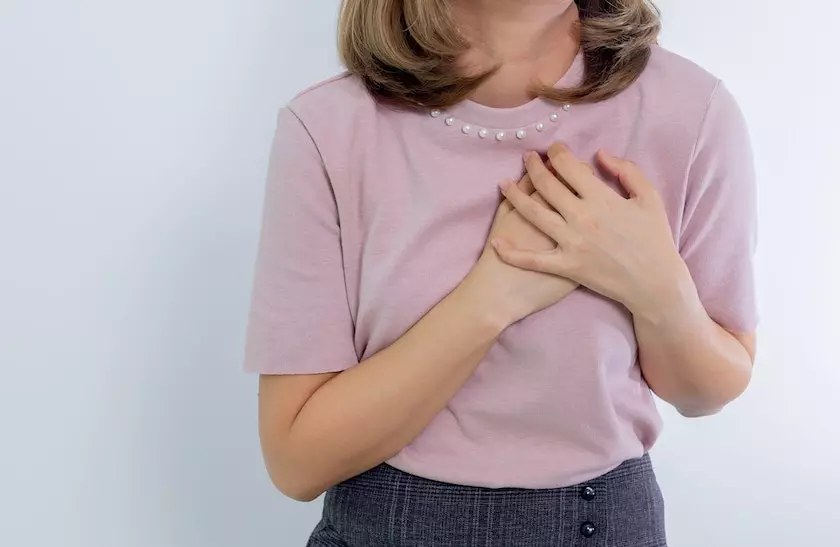 a women has out her hand on her breast due to breastpain