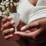 a woman holding flower among a menstrual cup