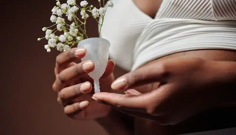 a woman holding flower among a menstrual cup